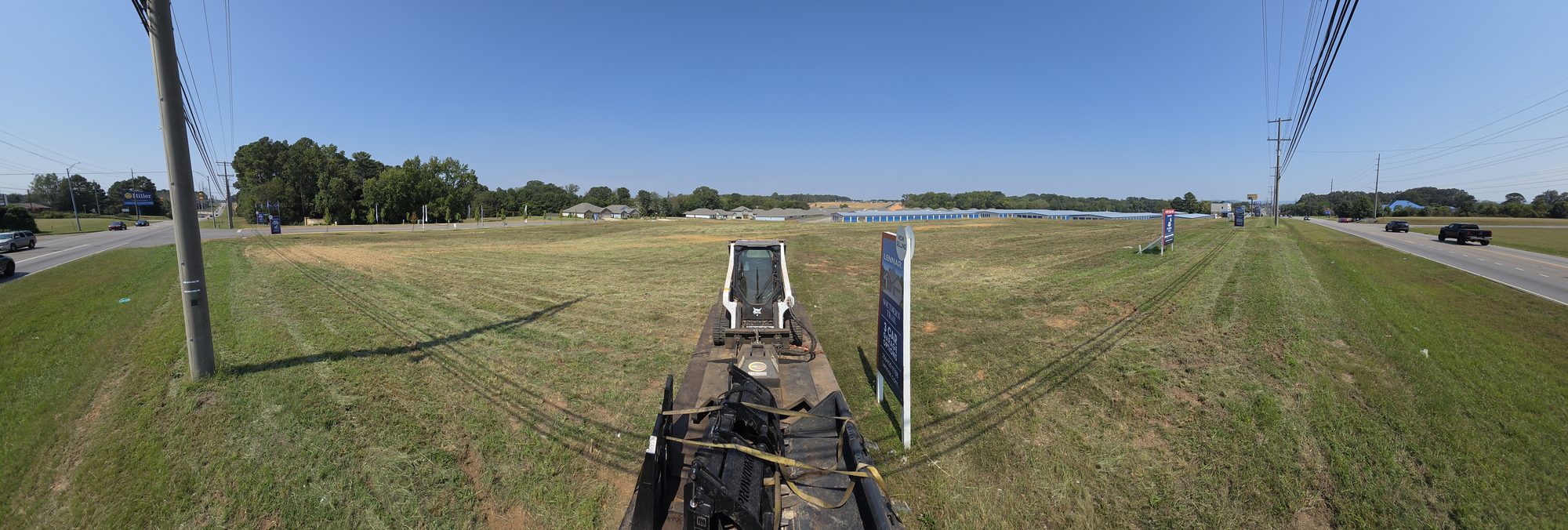 Panoramic view from the trailer of a large field cut with the brush cutter